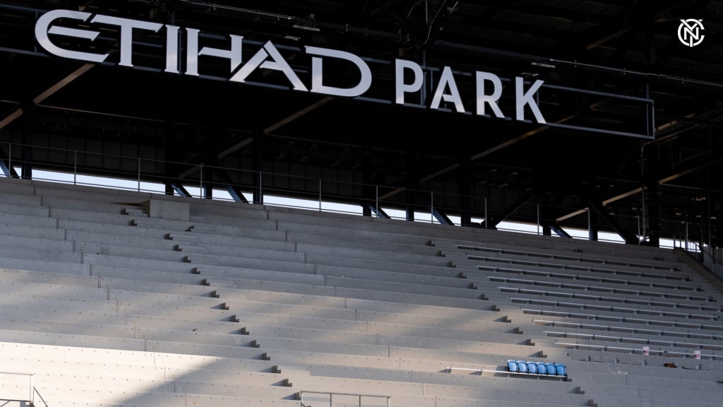 Workers installing the first seat at Etihad Park in the Supporters Section